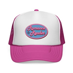 Op de afbeelding: Roze en witte truckerpet met een gebogen klep. De pet heeft een roze ovaal met de woorden "Romance Reader" in een scriptlettertype, en de woorden "happy endings only" zijn ook zichtbaar.