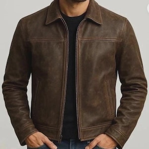 May include: Brown leather jacket with a collared neckline, a zipper closure, and two front pockets. The jacket has a classic design and a textured appearance. The sleeves are long, and the jacket appears to be well-fitted. The overall style is casual and suitable for various occasions.