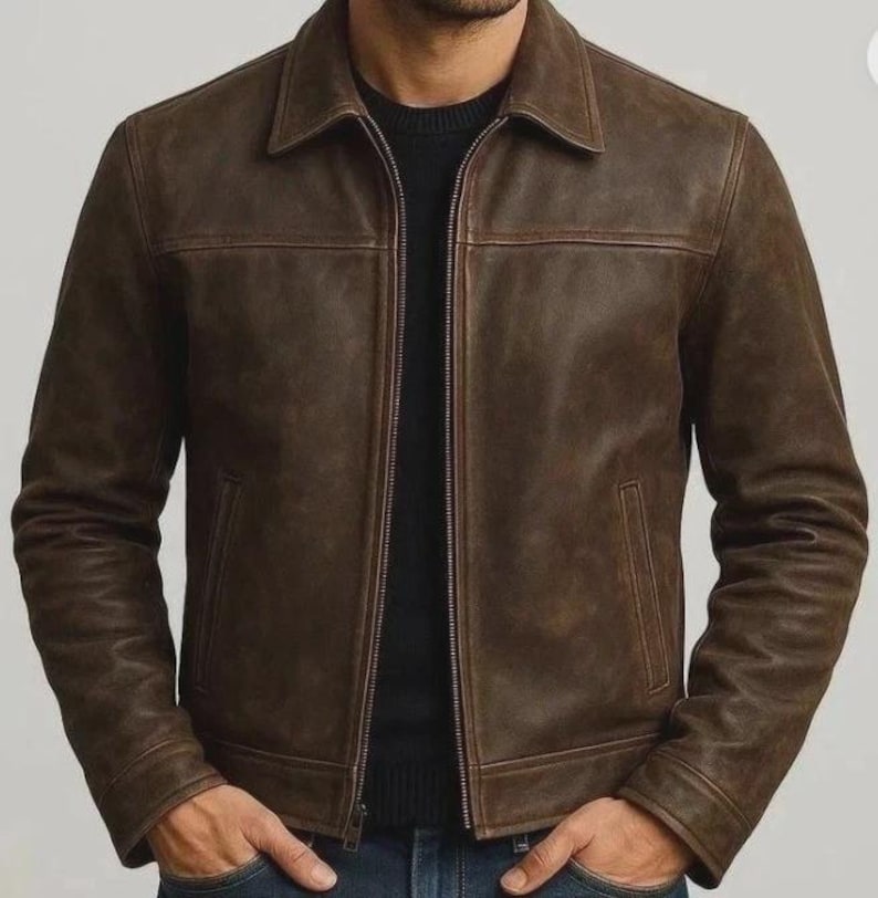 May include: Brown leather jacket with a collared neckline, a zipper closure, and two front pockets. The jacket has a classic design and a textured appearance. The sleeves are long, and the jacket appears to be well-fitted. The overall style is casual and suitable for various occasions.