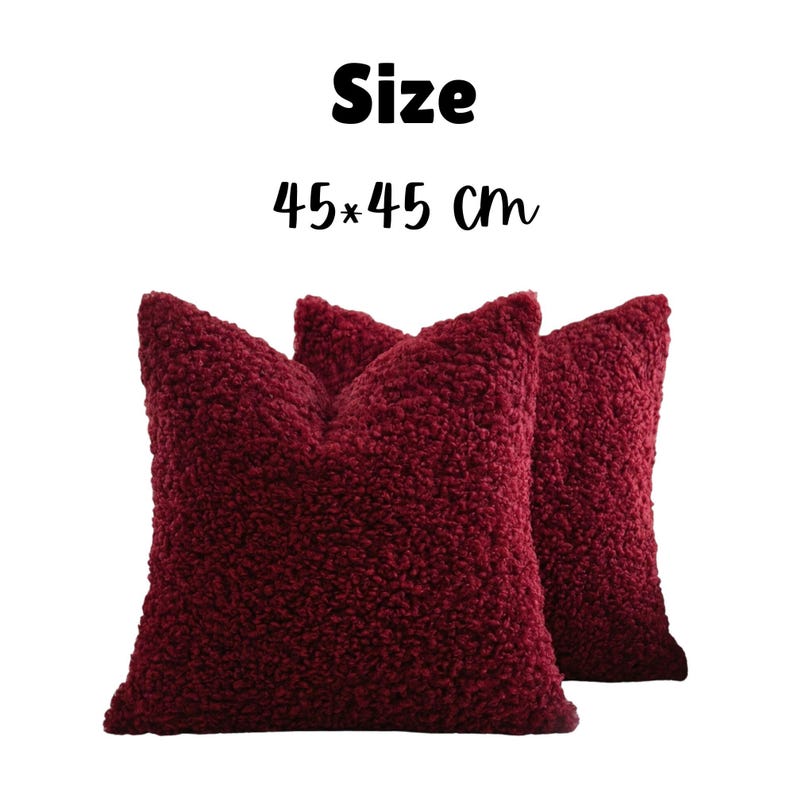 May include: Two square throw pillows in a deep burgundy color with a textured, curly sherpa-style fabric. The text "Size" and "45*45 cm" is displayed above the pillows, indicating their dimensions in centimeters for this set of two items.