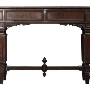 Op de afbeelding: Een donkerbruine houten console met twee lades en sierlijke gesneden details. De tafel heeft een rechthoekig blad, ondersteund door vier dikke, gesneden poten. Tussen de poten is een decoratief element aanwezig. De tafel is een klassiek meubelstuk.