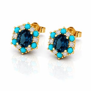 May include: A pair of gold stud earrings. Each earring features a dark blue oval gemstone surrounded by turquoise and small white gemstones. The earrings have a post and backing for secure wear.