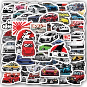 May include: A collection of car stickers featuring various sports cars in different colors and designs. Some stickers include Japanese text and graphics, such as the rising sun and the word "Monster". The stickers are die-cut and ready to apply.