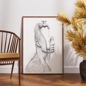 May include: Framed black and white art print featuring a surreal illustration of a human profile with a faucet on top of the head. The artwork is displayed in a wooden frame, leaning against a white wall. A wooden chair and decorative vase are in the foreground.