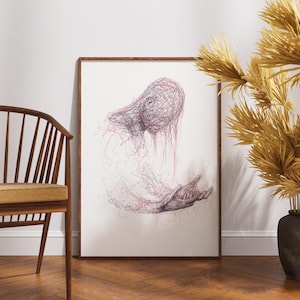 May include: A framed artwork featuring a detailed, abstract drawing of a figure with a head and outstretched hand. The artwork is rendered in shades of red and black on a white background. The frame is a warm brown. The artwork is displayed near a wooden chair and decorative dried plants.