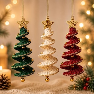 May include: Three hanging Christmas tree ornaments crafted from crocheted yarn in dark green, white, and deep red. Each spiral-shaped tree is topped with a small crocheted star and decorated with metallic gold beads along the edges and base.