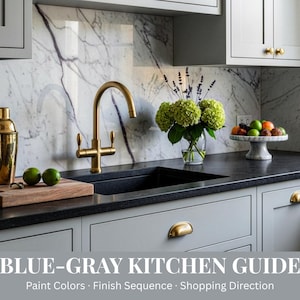Könnte beinhalten: Eine moderne Küche mit blau-grauen Schränken, einer schwarzen Arbeitsplatte und einer Marmorrückwand. Ein goldener Wasserhahn und Shaker befinden sich in der Nähe eines Holzschneidebretts mit Limetten. Eine Vase mit grünen Hortensien und eine Obstschale aus Marmor sorgen für Farbe. Der Text lautet "BLUE-GRAY KITCHEN GUIDE".