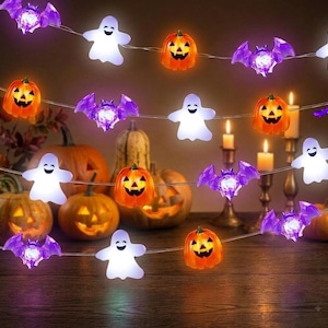 May include: A string of Halloween LED lights featuring alternating translucent purple bats, white ghosts, and orange jack-o'-lanterns. The decorative light strand is illuminated, showcasing the distinct shapes of the figures against a dark background.