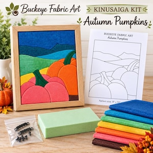 May include: A Buckeye Fabric Art Kinusaiga kit titled Autumn Pumpkins, featuring a framed fabric landscape of orange and pink pumpkins, a green foam block, a stack of colorful fabric swatches, and a pattern sheet with 8 inch by 10 inch text.