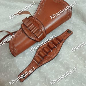 Puede incluir: Una funda de cuero color canela con una sección de cartuchera integrada y una muñequera de cuero a juego con cinco bucles para cartuchos, ambas decoradas con patrones florales en relieve y costuras blancas, marcadas con el texto Khanleather1.