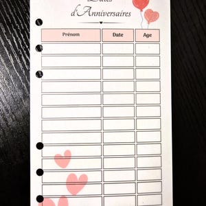 May include: A white planner insert page titled Dates d'Anniversaires with a three-column table for Prénom, Date, and Age. The page features pink heart illustrations, two heart-shaped balloons, and six circular binder holes along the left side.