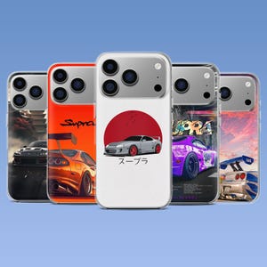May include: Five clear smartphone cases featuring various Toyota Supra car designs. The designs include a grey car with a red circle, an orange car, a purple car with Japanese text, and a silver car with a large rear wing against a sunset sky.