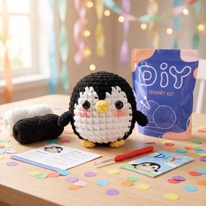 Puede incluir: Un kit de ganchillo DIY con un ping&uuml;ino hecho a mano. El ping&uuml;ino es blanco y negro con pico y patas amarillas, y mejillas rosas. El kit incluye hilo, un ganchillo e instrucciones. Confeti colorido est&aacute; esparcido alrededor del kit.