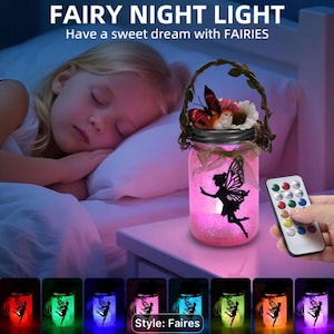 May include: A glass jar night light with a pink glow, featuring a black fairy silhouette, a vine handle, and a decorative butterfly topper. The text FAIRY NIGHT LIGHT and Have a sweet dream with FAIRIES is visible. Includes a remote control.