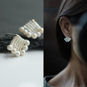 May include: A pair of stud earrings featuring a fan-shaped design constructed from small white seed beads woven into a grid pattern, finished with a row of five round white pearls along the bottom edge and a single gold-toned metal post backing.