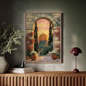 May include: A framed oil painting depicting a stone archway framing a golden domed structure at sunset. The scene includes two terracotta pots with white flowers, tall dark cypress trees, and pink flowering vines against a warm sky.