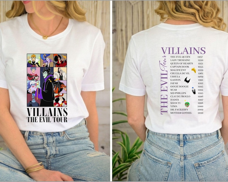 Op de afbeelding: Wit T-shirt met een afbeelding van Disney-schurken en de tekst "VILLAINS THE EVIL TOUR" op de voorkant. De achterkant van het shirt toont de schurken en hun debuutjaren in paarse tekst.