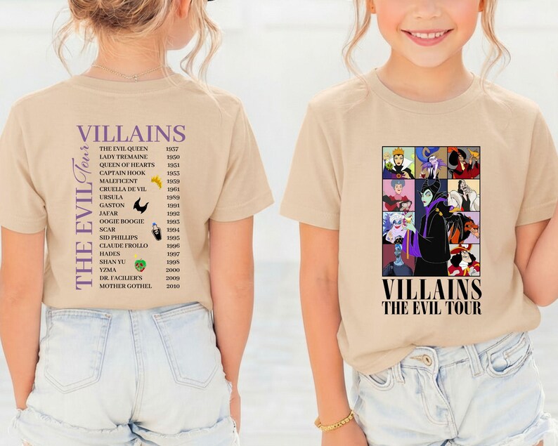Op de afbeelding: Twee beige T-shirts met Disney-schurkenafbeeldingen. E&eacute;n toont een lijst met schurken en hun debuutjaren. De andere toont een collage van schurkenportretten met de tekst "Villains The Evil Tour."