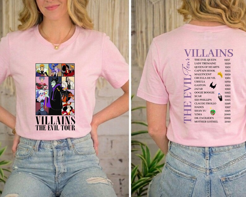 Op de afbeelding: Lichtroze T-shirt met een afbeelding van tekenfilm-schurken en de tekst "VILLAINS THE EVIL TOUR". De achterkant van het shirt geeft de schurken en hun jaren weer.