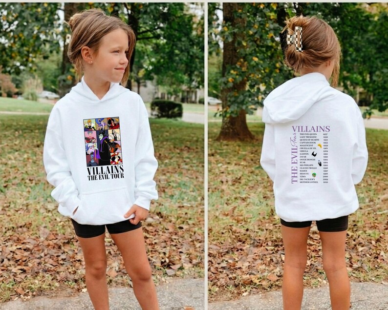 Op de afbeelding: Witte hoodie met een afbeelding op de voorkant met verschillende tekenfilm-schurken en de tekst "Villains The Evil Tour". De achterkant van de hoodie heeft een lijst met schurken. Het model draagt een zwarte short.