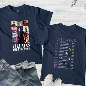 Op de afbeelding: Marineblauwe T-shirts met een grafisch ontwerp met Disney-schurken. E&eacute;n shirt toont een collage van schurken met de tekst "Villains The Evil Tour". Het andere shirt geeft schurken en hun debuutjaren weer.