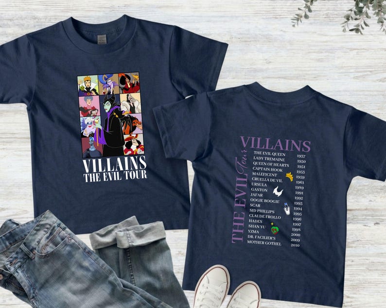 Op de afbeelding: Marineblauwe T-shirts met een grafisch ontwerp met Disney-schurken. E&eacute;n shirt toont een collage van schurken met de tekst "Villains The Evil Tour". Het andere shirt geeft schurken en hun debuutjaren weer.