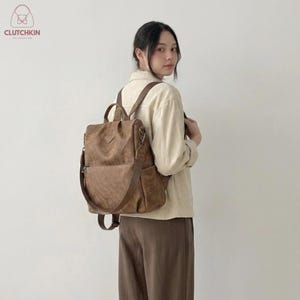Mochila de couro genuíno, versátil e de cor sólida, resistente e feita de PU, ideal para viagens, com fecho de aba seguro.