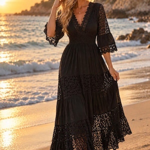 Peut inclure: Une robe longue noire dotée d'un décolleté en V profond, de manches cloche trois-quarts et d'une taille ajustée. Le vêtement est orné de panneaux en dentelle complexe sur le corsage, les manches et la jupe à étages, créant un aspect texturé.