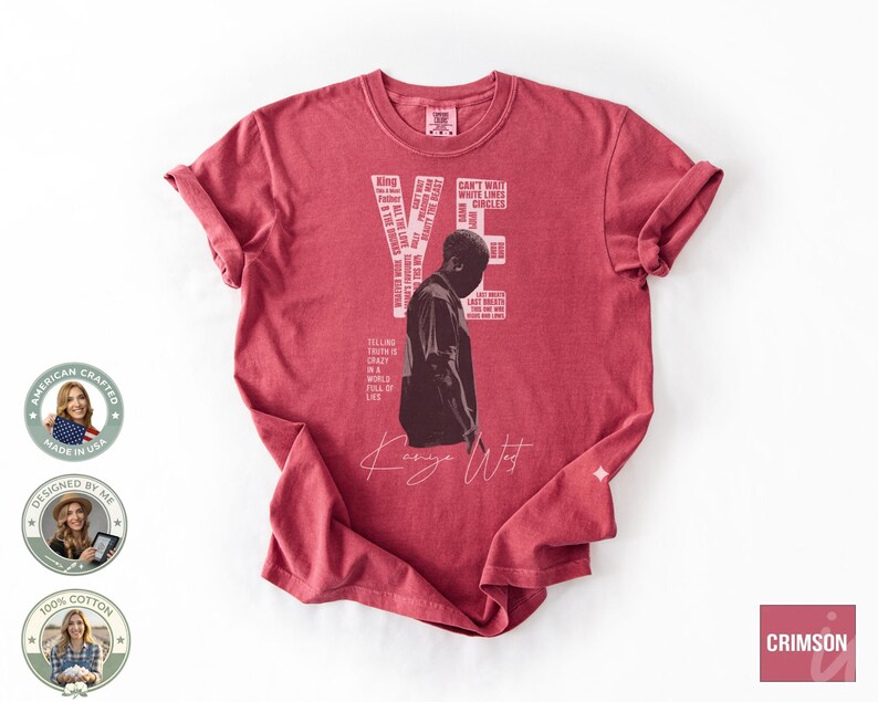May include: A red t-shirt featuring a graphic of Kanye West with the word "YE" and other text. The shirt includes the text "AMERICAN CRAFTED MADE IN USA DESIGNED BY ME 100% COTTON" and the word "CRIMSON".