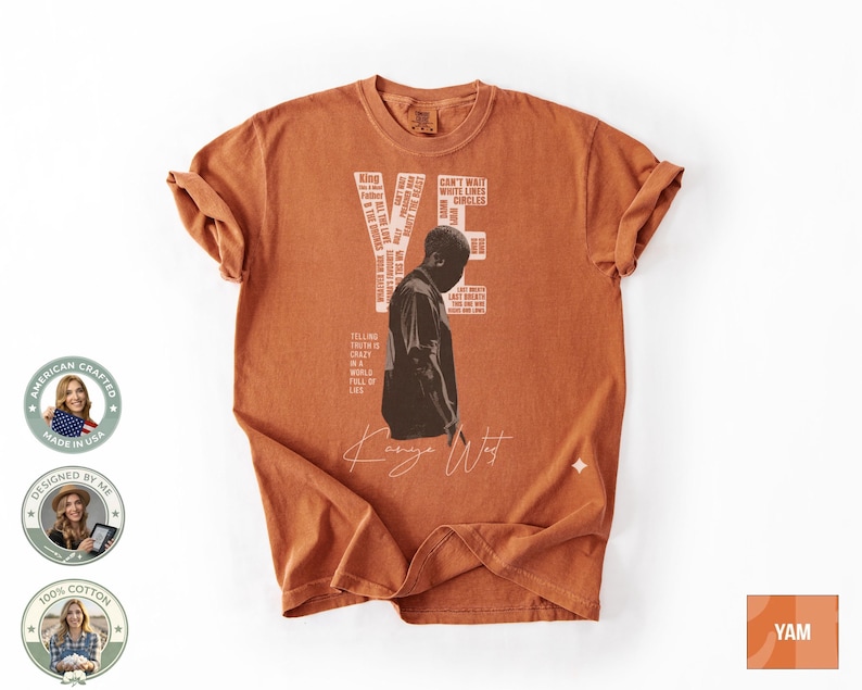 May include: Burnt orange t-shirt featuring a graphic of a person and the text "YE" with additional text. The shirt also has the signature "Kanye West" in white script. Made of 100% cotton.