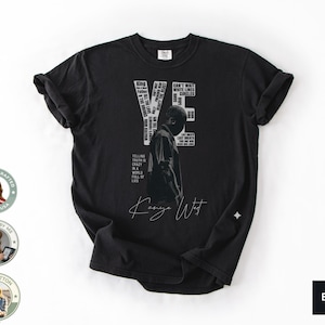 May include: Black t-shirt featuring a graphic of a person with the text "YE" and other phrases. The shirt includes the signature "Kanye West". The shirt is made of 100% cotton and is designed in the USA.