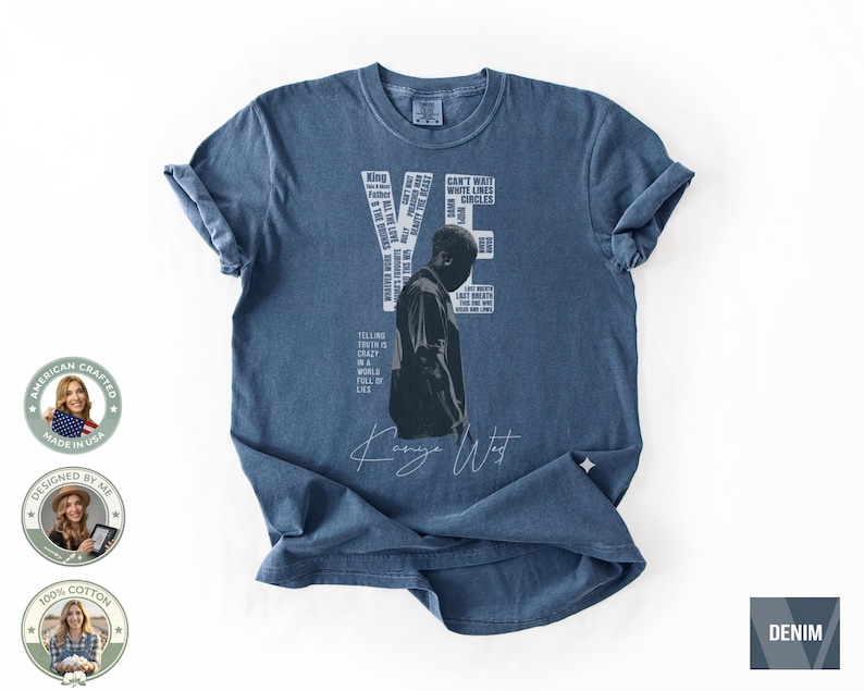 May include: Denim blue t-shirt featuring a black and white image of a person and the text "YE" with various words and phrases. The shirt also includes the text "Kanye West" in a handwritten font. Made of 100% cotton.