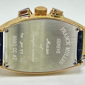 Puede incluir: Un reloj Franck Muller Geneve Master of Complications en tono dorado con caja en forma de tonel. La parte posterior de acero inoxidable presenta texto grabado que incluye la marca, el modelo 8880 CC AT y el n&uacute;mero de serie 77, con correa negra.