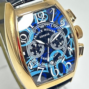 Puede incluir: Un reloj cron&oacute;grafo Franck Muller Geneve en tono dorado con correa de cuero negro. La esfera presenta un patr&oacute;n de camuflaje azul y negro con grandes n&uacute;meros ar&aacute;bigos blancos, tres subesferas, una ventana de fecha y el texto CAMOUFLAGE.