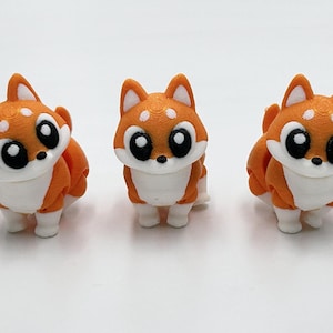 Peut inclure: Trois petites figurines de renards orange et blanc imprim&eacute;es en 3D avec de grands yeux noirs, des marques faciales blanches et des oreilles pointues. Chaque renard est repr&eacute;sent&eacute; debout avec une texture lisse et stratifi&eacute;e sur le plastique.