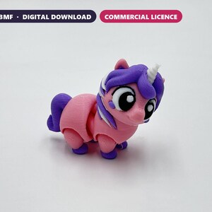 Peut inclure: Une figurine de licorne imprimée en 3D rose et violette avec de grands yeux noirs et blancs, une corne blanche et une texture en couches. L'image inclut le texte STL + 3MF - DIGITAL DOWNLOAD et COMMERCIAL LICENCE en haut.