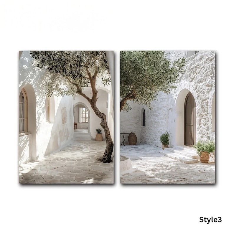 May include: A two-panel wall art set depicting a sunlit Mediterranean courtyard with white stone walls, arched doorways, and a large olive tree. The scene features a paved stone ground, shadows cast by the tree, and potted plants in a bright, outdoor setting.