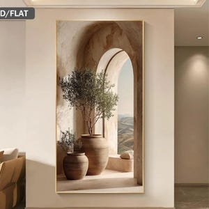 Può includere: Una stampa artistica da parete rettangolare verticale con un arco in pietra beige che incornicia una vista paesaggistica. Due grandi vasi in terracotta marrone contenenti alberi di ulivo verdi si trovano in primo piano in toni neutri.