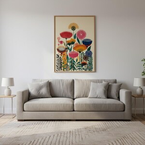 May include: A framed floral art print featuring colorful stylized flowers in shades of red, yellow, pink, and blue. The artwork is displayed above a beige sofa in a living room setting. The print has a wooden frame.