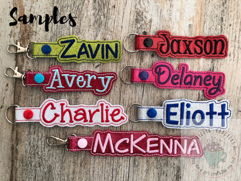 Puede incluir: Seis llaveros personalizados con diferentes nombres bordados en ellos. Los llaveros est&aacute;n hechos de tela y tienen un peque&ntilde;o c&iacute;rculo de tela de color contrastante en la parte superior. Los nombres son: Zavin, Jaxson, Avery, Delaney, Charlie y McKenna.