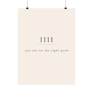 Pu&ograve; includere: Un poster beige con il numero "1111" in nero, sopra la frase "you are on the right path". Il poster &egrave; tenuto da due clip nere nella parte superiore.