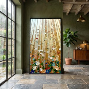 以下が含まれることがあります： テクスチャ加工された花の風景を描いた、大きな額入りの絵画。このアートワークは、赤、青、白、ピンクの色合いのカラフルな花のフィールドを、木のように見える金色の垂直線の背景に示しています。絵画は大きな窓のある部屋に展示されています。