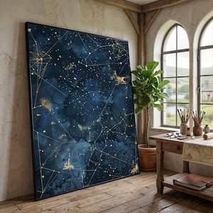 May include: Large framed canvas art with a celestial design. The artwork features a deep blue background with gold constellations and connecting lines. The piece is displayed in a room with wooden floors and a large window.