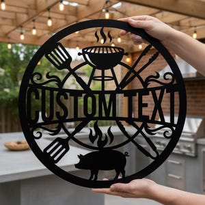 Peut inclure: Panneau de barbecue en métal noir avec l'inscription "CUSTOM TEXT" au centre. Le panneau représente un grill, des ustensiles, une silhouette de cochon et des flammes. Le panneau est tenu par une personne.