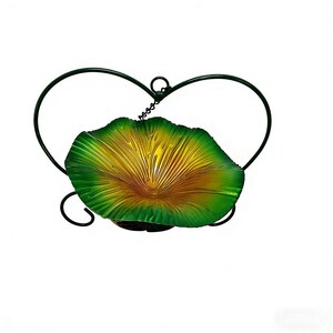 May include: A decorative metal wall hanging featuring a stylized leaf-shaped bowl in shades of green and yellow. The bowl is supported by a dark green, heart-shaped frame. The piece is designed to be mounted on a wall.