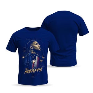 May include: A royal blue short-sleeved t-shirt featuring a graphic print of Kylian Mbapp&eacute;. The design includes a portrait, a full-body action shot, the text "MBAPP&Eacute;" in gold, "BUILT DIFFERENT" below it, and the Eiffel Tower in the background.