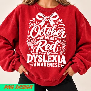 May include: A red crewneck sweatshirt featuring white graphic text that reads In October We Wear Red for Dyslexia Awareness. The design includes a large bow at the top, a small open book, a brain illustration, and a lightbulb icon.