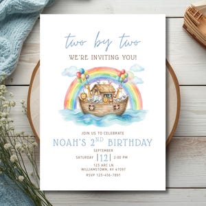 May include: A rectangular birthday invitation card featuring a watercolour illustration of a wooden ark filled with animals under a rainbow. The text reads: two by two, WE'RE INVITING YOU!, JOIN US TO CELEBRATE, NOAH'S 2ND BIRTHDAY, SEPTEMBER 12, 2:00 PM, 123 ARC LN, WILLIAMSTOWN, KY 41097, RSVP 123-456-7891.