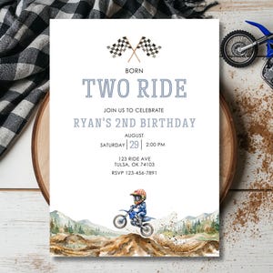 May include: A rectangular birthday invitation card featuring two crossed checkered flags at the top, the text BORN TWO RIDE, RYAN'S 2ND BIRTHDAY, and event details, with a watercolor illustration of a child on a dirt bike at the bottom.