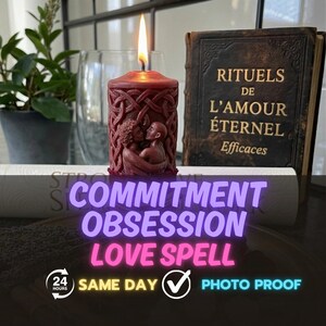 Op de afbeelding: Een bordeauxrode kaars met een gebeeldhouwd ontwerp van omarmende figuren en Keltische knopen, met een brandende vlam. De kaars staat naast een boek met de titel "RITUELS DE L'AMOUR ÉTERNEL". De tekst "COMMITMENT OBSESSION LOVE SPELL" is ook zichtbaar.